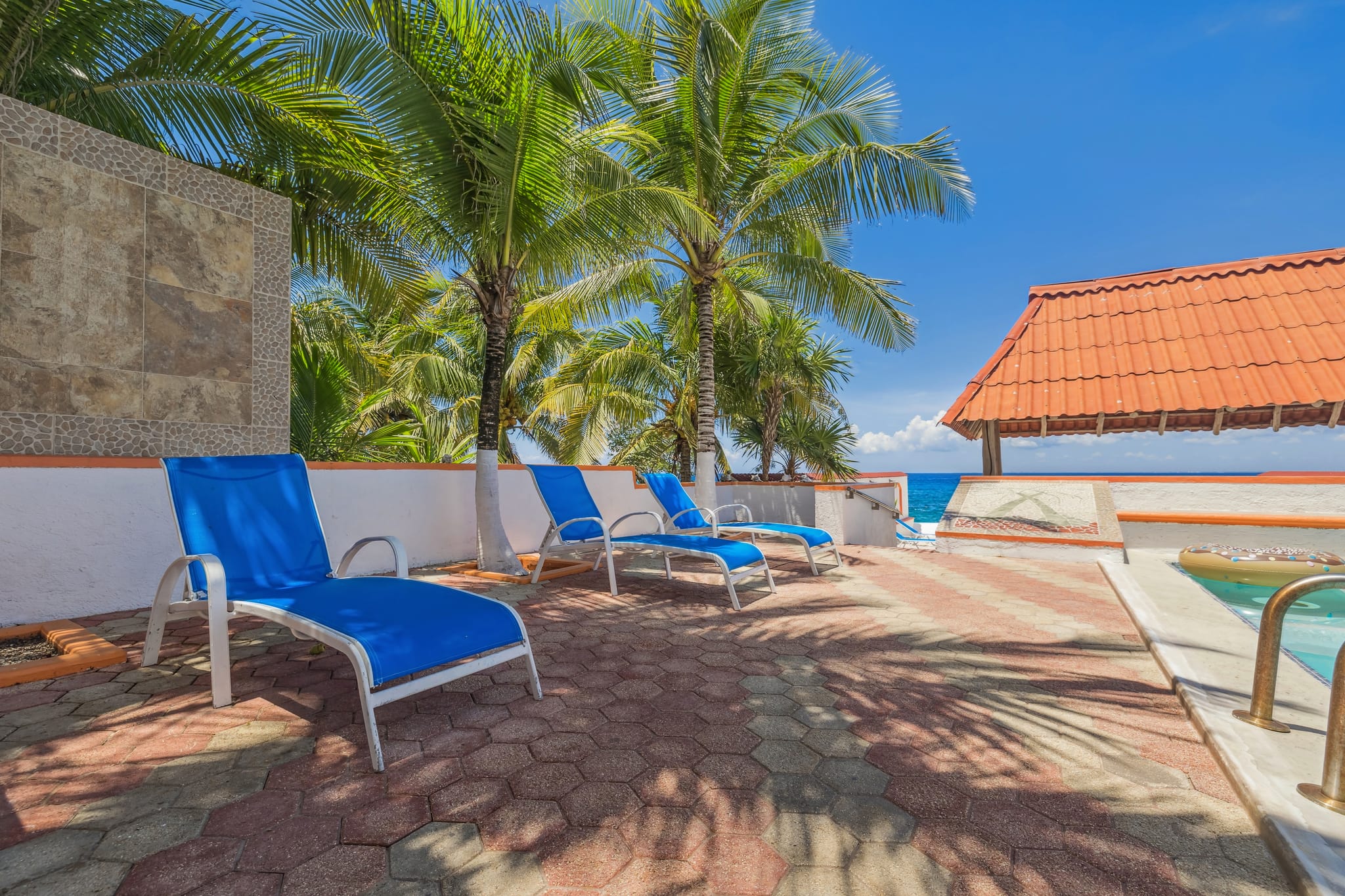 The palapa and pool deck at Villa Princesa, palms and the sea beyond